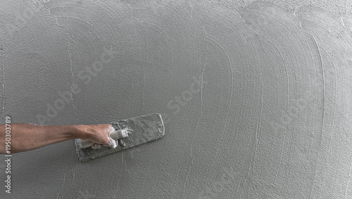 Hand plasterer plastering cement wall background, hand worker brush rough concrete floor for smooth manual well free space for text with occupations about building construction site