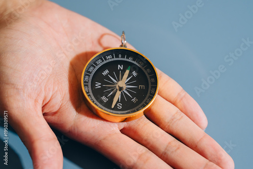 Obraz na płótnie Compass rests on open palm, showcasing its detailed markings and needle pointing north