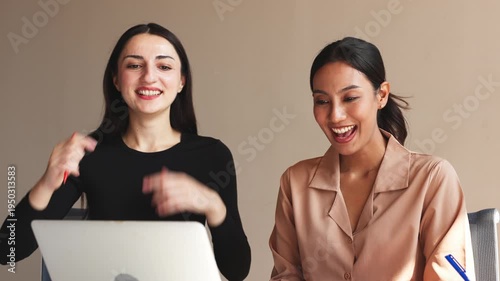 Three business professionals discussing charts and reports while analyzing information on laptop during collaborative office meeting.