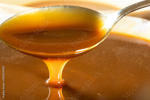 Wallpaper Mural Sweet caramel sauce dripping from spoon, liquid caramel close-up. Torontodigital.ca