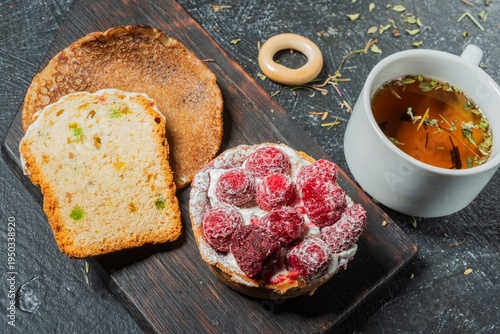 Still life - cake with decoration of sweet strawberries on the table. Green tea - food on a dark background