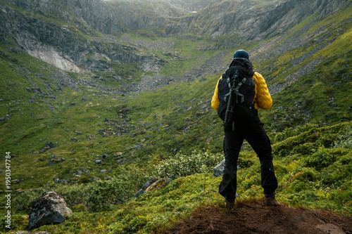 Man with backpack from behind with mountain background in Nordic Norway