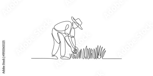 Man bending over to tend to plants in a garden or field outdoors gardening hat