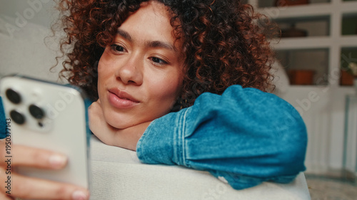 Woman Relaxing At Home With Smartphone