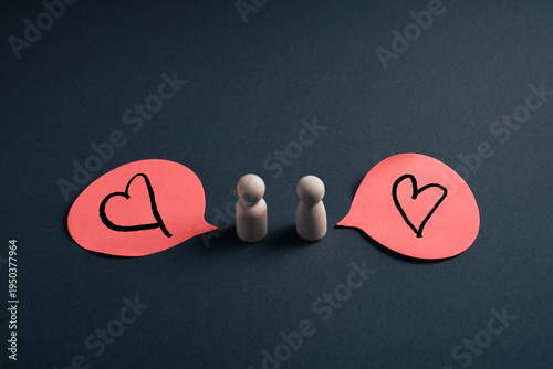 Mutual love concept with wooden figures and heart speech bubbles symbolizing emotional reciprocity