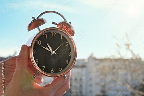 hands changing the time on alarm clock