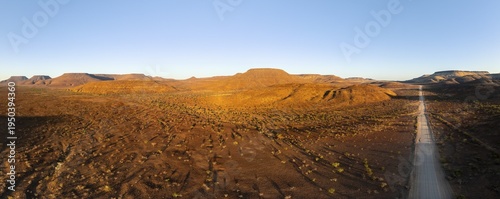 Aerial view, infinite space, straight road leads through dry desert landscape, hills in Damaraland, Namibia