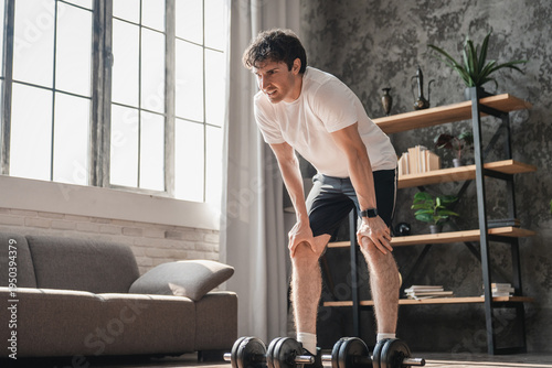 Dumbbells, resting and strong man in fitness training, exercise or home workout for wellness, lifting or balance. Development, challenge or male athlete with weights for muscle, power or body growth