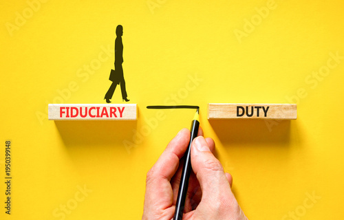 Fiduciary duty words symbol. Concept words Fiduciary duty on beautiful wooden blocks. Beautiful yellow background. Businessman hand. Business and Fiduciary duty words concept. Copy space.