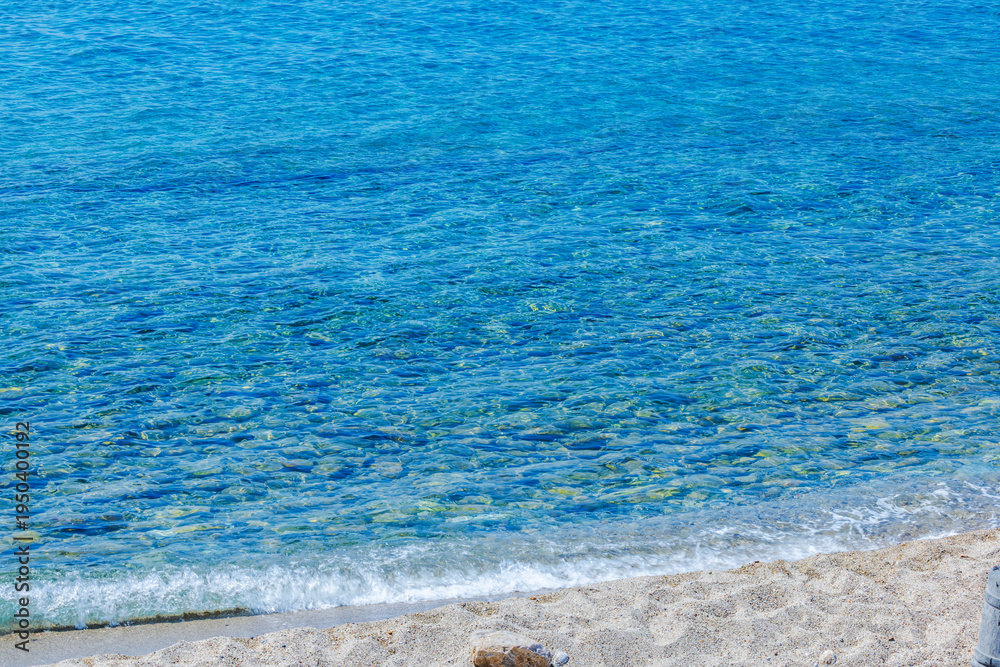 Obraz premium Beautiful view of Aegean Sea with clear blue water and gentle waves washing sandy beach. Kos. Greece.