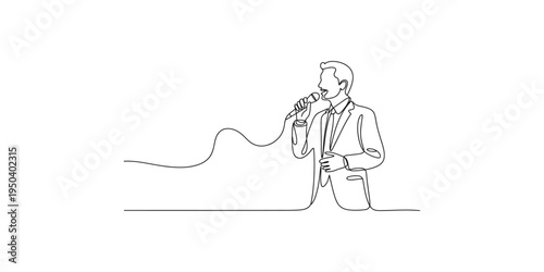 Man in a suit holding a microphone and speaking into it confidently on a white