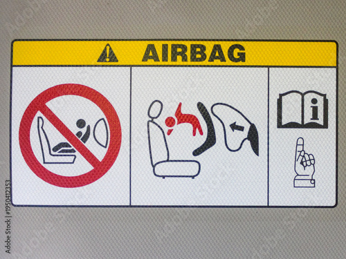 Photography Airbag warning label on a car sun visor, showing safety instructions and danger warnings for rear-facing child seats in the front passenger seat