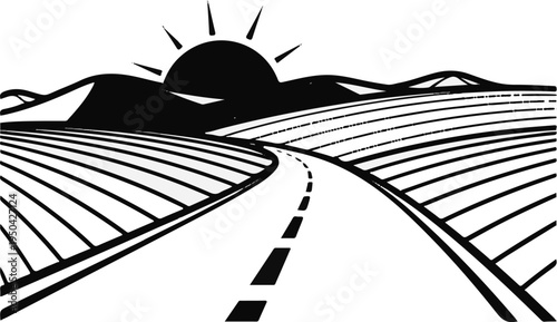 A winding road leads through agricultural fields towards distant hills at sunrise