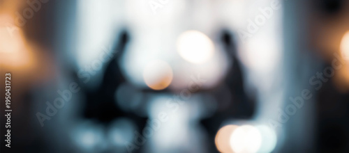 Wallpaper Mural An abstract image featuring silhouettes of two people engaged in conversation or discussion in a softly blurred setting with warm light bokeh. Torontodigital.ca