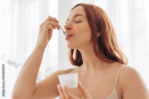 Close up of pregnant woman eating yogurt, healthy pregnancy diet concept