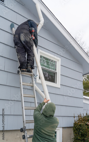 manual worker installing radon mitigation system outside the house