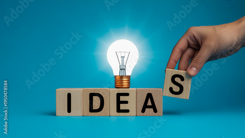 A hand holding a block with an 's' on it next to the word ideas and a light bulb