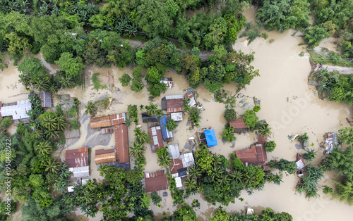 An aerial view shows floodwaters inundating homes, roads, and surrounding vegetation after heavy rainfall