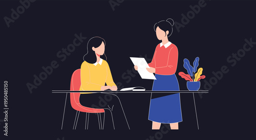 Two professional women collaborate in a modern office where one woman stands and reviews a document with her colleague who is seated at a desk.