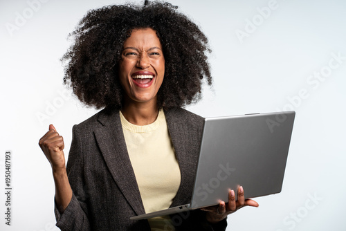 Portrait of attractive surprised excited smiling business woman hold hand up looking at laptop screen, isolated over grey background, Winner businesswoman with success