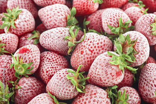 Frozen strawberries as background. Appetizing strawberry with hoarfrost. Food background.