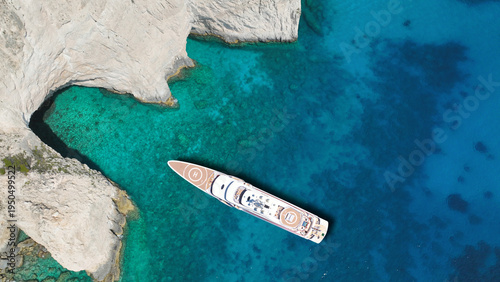 Aerial drone top down photo of luxury yacht anchored in paradise island bay with turquoise crystal clear sea