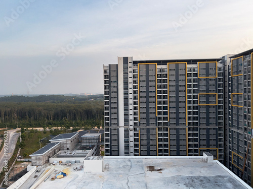 Cyberjaya high-rise apartment construction forest background. 