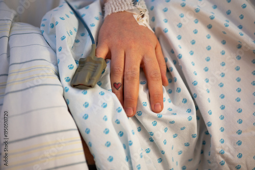 Hand mit Messgerät im Krankenhaus. Herzotattoo