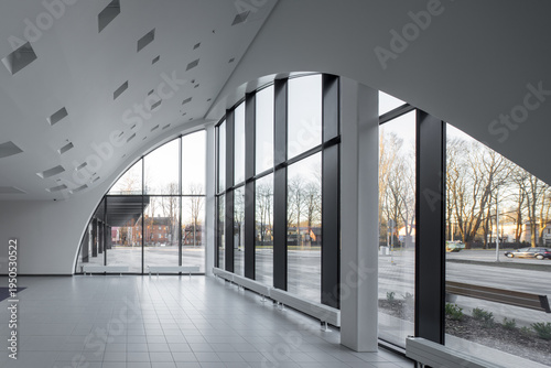 Modern hospital atrium interior with large windows and minimalist architecture.