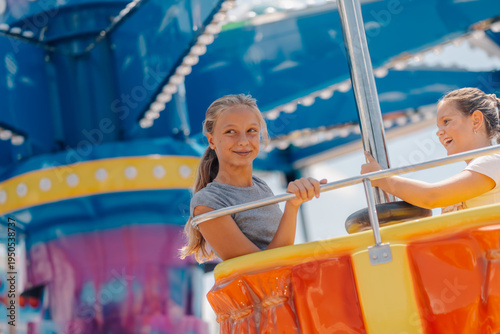 Foto Two girls having fun on a spinning ride at amusement park