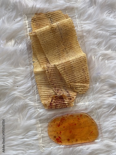 Dried shredded squid with spicy seafood dipping sauce, Asian street food snack on white background