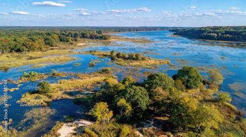 Elevated view captures dense forest bordering a wide river system with extensive wetlands