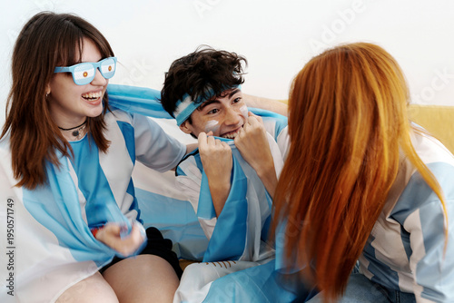 Fotografia Argentina football fans cheering watching game on couch