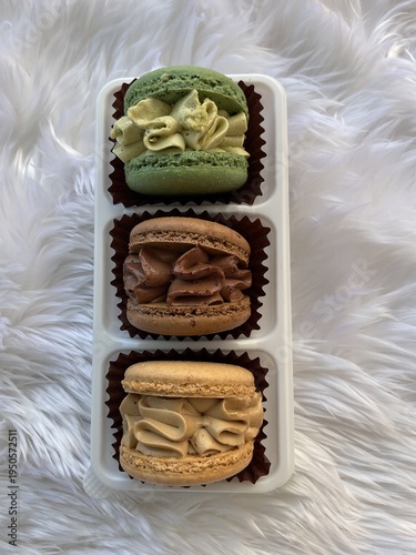 Tripleks makarons creamy,Chocolate and green macarons on white plate, minimal dessert concept
