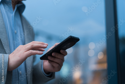 Photos Businessman holding smartphone and interacting with touch screen interface near