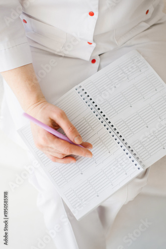Doctor Writing in Medical Notebook or Planner