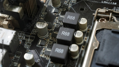 Tableau sur toile Close-up of motherboard with black capacitors labeled R68 and R66, CPU socket area, and various electronic components