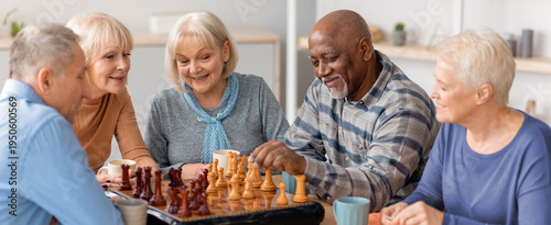 Canvas-taulu A group of five seniors gathers around a chessboard in a bright indoor space