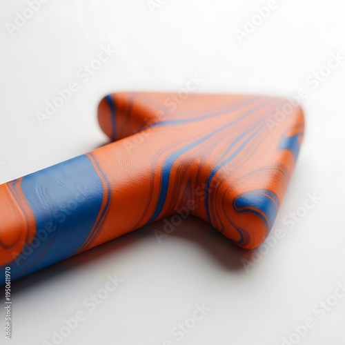 A close up view of a smooth orange and blue marbled object shaped like a stylized letter arrow