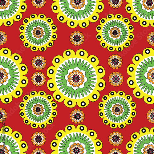 Seamless decorative floral pattern featuring circular folk style flowers with ornamental details in bright yellow, green and blue colors on a red background. Perfect for fabric, wallpaper, wrapping pa