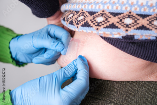 Photos Hands wearing blue gloves applying a fentanyl patch.