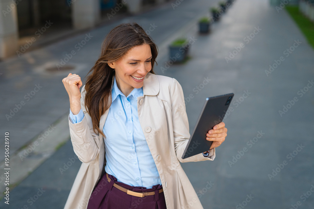Fototapeta premium Businesswoman celebrating success after reading good news on tablet