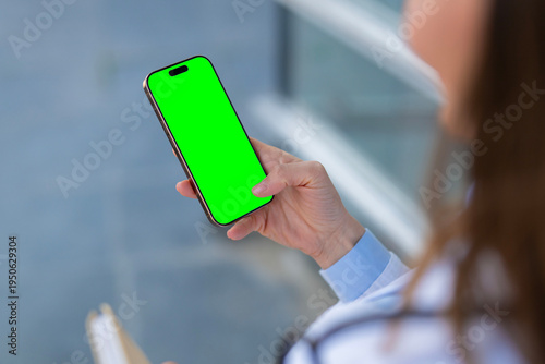Doctor holding smartphone with green screen for medical app