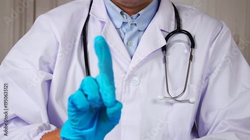 Un médecin faisant le signe non avec un doigt. Il est habillé en blouse blanche et porte un stéthoscope. 