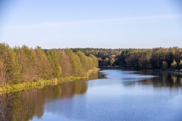 Plexiglas schilderij Reflectie Gele herfstbomen langs kalme rivieroever  © rsooll