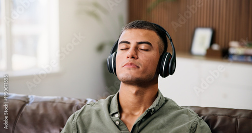 Photos Man, headphones and relax on sofa with streaming, chill audio and break on weekend in home