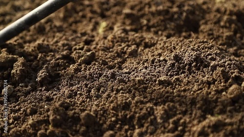 Farmer using a hand hoe  loosening fertile soil for planting