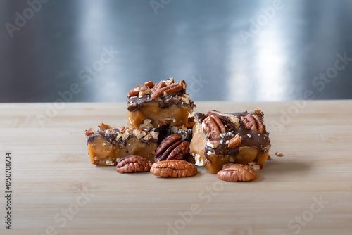Delicious chocolate caramel pecan candy pieces arranged on a wooden surface
