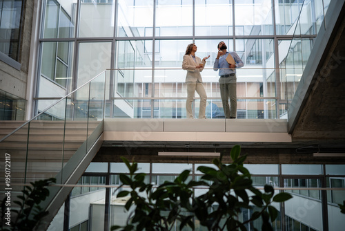 Fotografía Business colleagues having meeting and conversation overlooking modern office at
