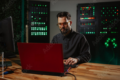Fotografie It technician analyzing data in server room